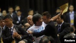 Polisi Hong Kong memaksa anggota legislatif Leung Kwok-hung keluar dari ruangan di mana Li Fei berpidato di Hong Kong (1/9).
