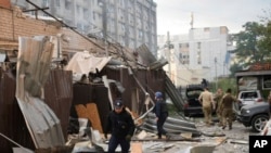 Petugas polisi dan petugas penyelamat berjalan di depan restoran RIA Pizza yang hancur akibat serangan Rusia di Kramatorsk, Ukraina, Selasa, 27 Juni 2023. (Foto: via AP)