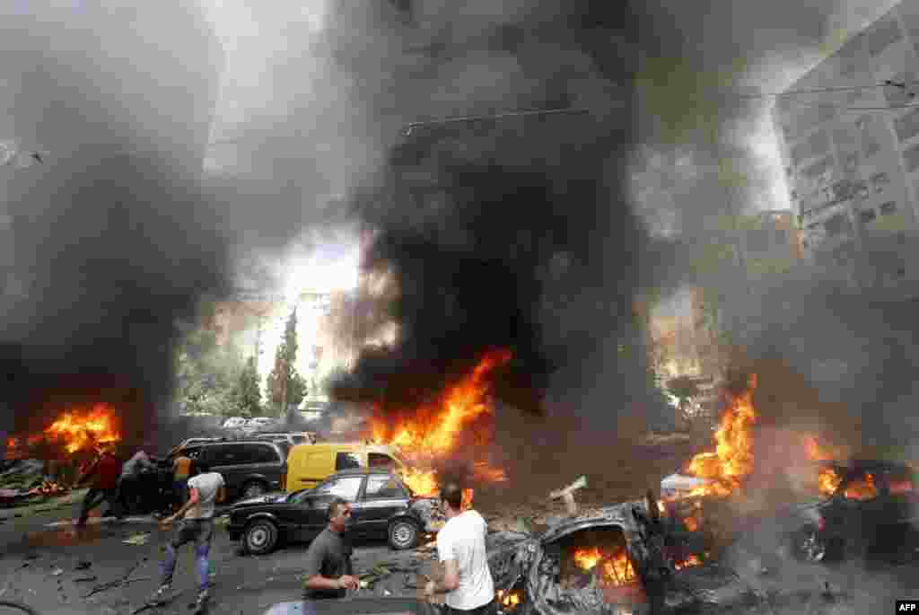 Warga berkumpul di lokasi ledakan di kawasan Bir al-Abed, kubu kelompok militan Hizbullah di Beirut selatan yang diguncang oleh serangan bom mobil.