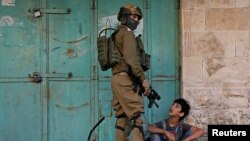 An Israeli soldier detains a Palestinian boy during an anti-Israel protest in Hebron in the Israeli-occupied West Bank, Nov. 29, 2019. Palestinian officials said Nov. 30 that Israeli troops had shot and killed a teenager near Hebron.