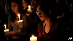 Natalynn Rivis, a student at University of Nevada Las Vegas, right, takes part in a vigil Monday, Oct. 2, 2017, in Las Vegas, Nevada.