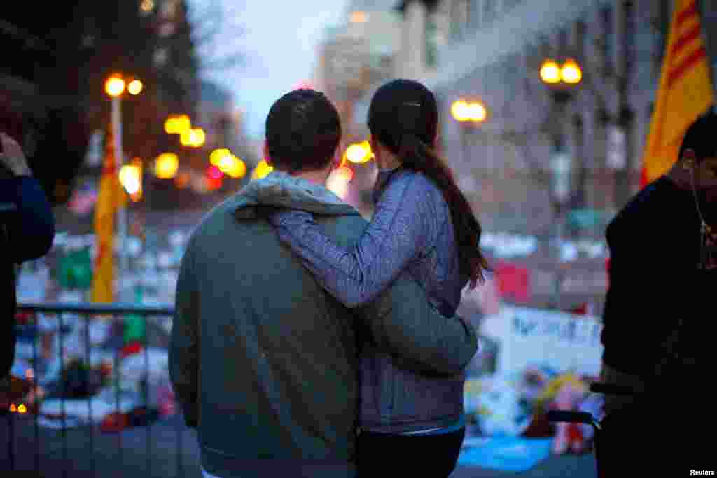 A couple embraces at a memorial to the bombing victims on Boylston Street, April 21, 2013.