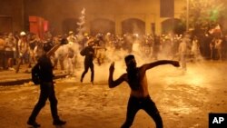 Waandamanaji wakiwatupia polisi mawe Agosti 9, 2020, kufuatia mlipuko wa Jumanne Agosti 4 ulioharibu eneo la Beirut, Lebanon. 
