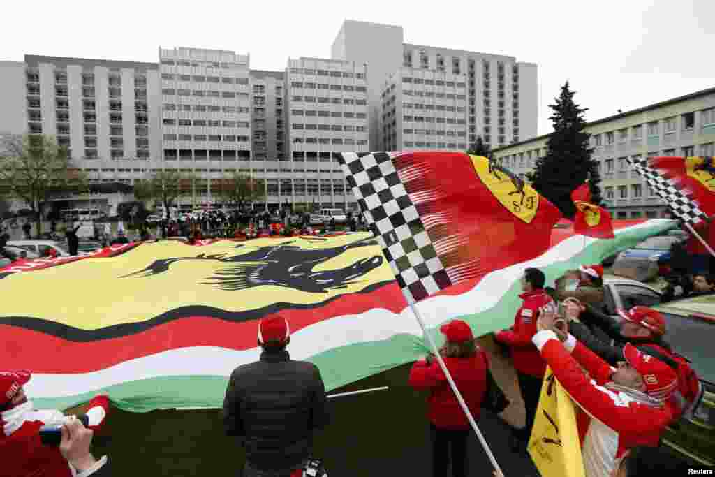 Para penggemar Michael Schumacher dari Perancis, Italia dan Jerman membentangkan bendera Ferrari raksasa saat berkumpul dalam suasana hening untuk memberikan penghormatan ulang tahun ke-45 kepada mantan juara dunia tujuh kali Formula Satu, Michael Schumacher, di depan rumah sakit CHU unit gawat darurat di Grenoble, Alpen Perancis, di mana bintang balap itu dirawat.