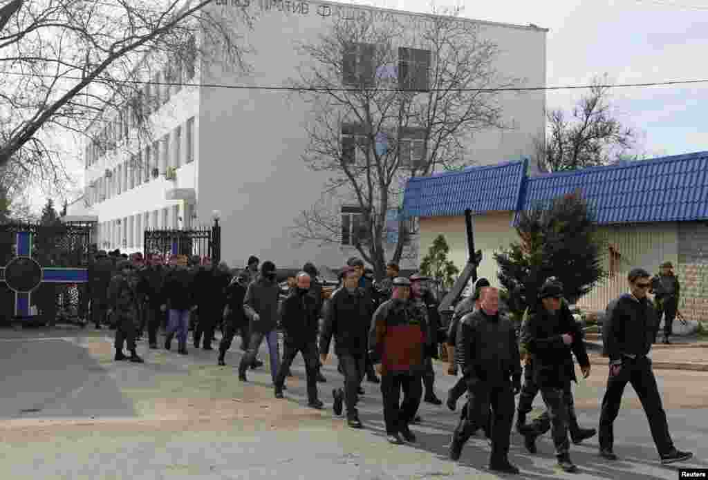 Members of Crimean self-defense units walk in formation while leaving the territory of the naval headquarters in Sevastopol, March 19, 2014.