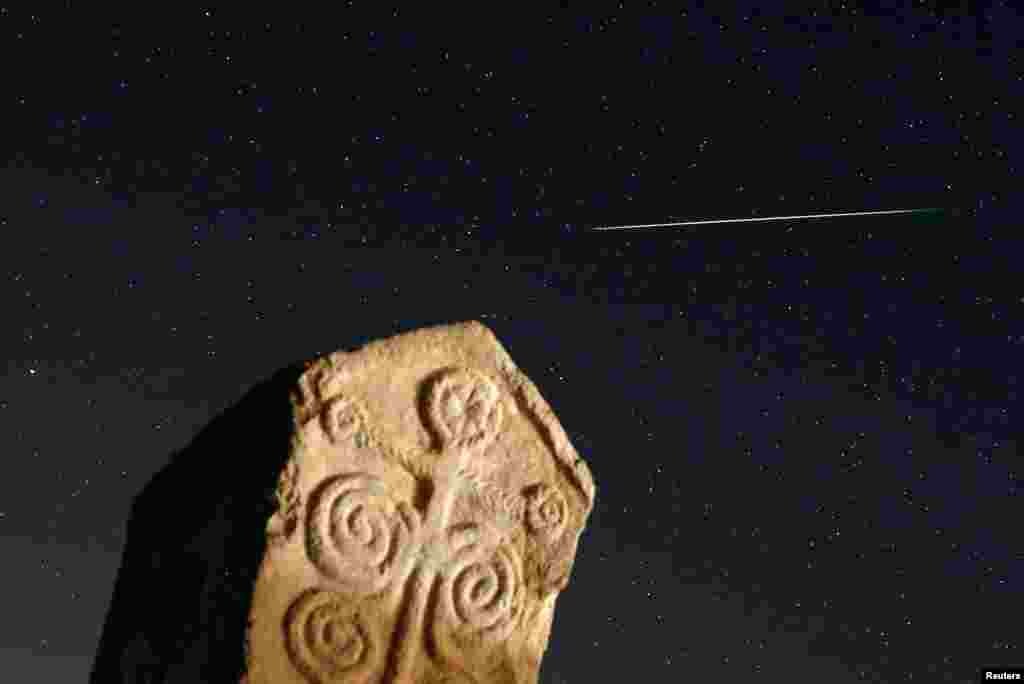 A meteor streaks past stars in the night sky above medieval tombstones in Radmilje near Stolac, south of Sarajevo, Bosnia and Herzegovina.