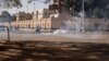 Pasukan keamanan menembakkan gas air mata untuk membubarkan massa yang mendukung militer di Ouagadougou, Burkina Faso, Minggu (23/1). 