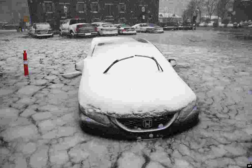A car sits in floodwaters from Boston Harbor on Long Wharf in Boston, Jan. 4, 2018. 