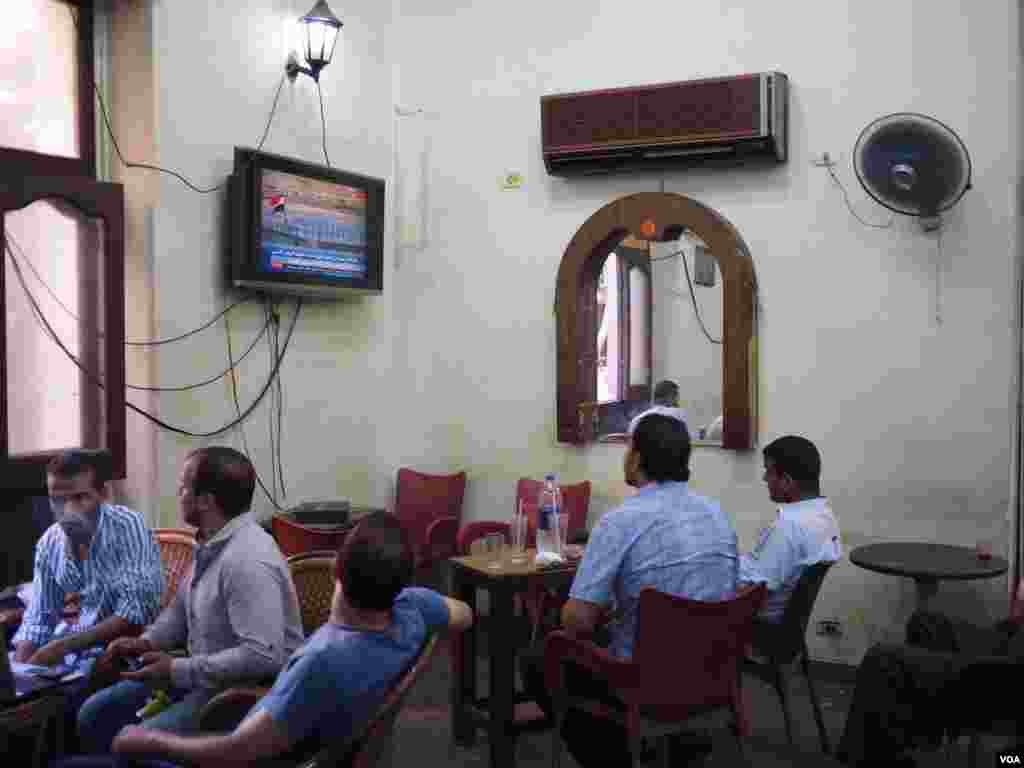 Egyptian men watch the live streaming for the new Suez channel branch on the Egyptian TV on a cafe downtown Cairo, Egypt, August 6, 2015. (Hamada Elrasam/VOA)