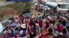 Cambodian garment factory workers ride on the back of a truck as they head to their homes at the evening traffic jump of Sre Cheah village outside Phnom Penh, Cambodia, Saturday, Jan. 11, 2020. (AP Photo/Heng Sinith)
