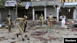 Afghan security force members inspect the site of a suicide attack in Jalalabad, April 18, 2015. 