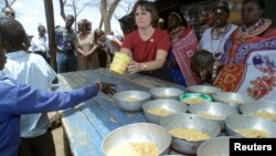 Catherine Bertini, former Executive Director of the World Food Programme (WFP), dishes out lunch to pupils, (File photo).