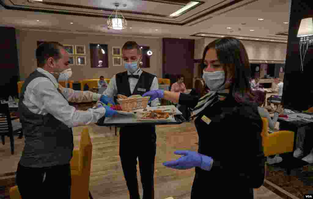 Masks and gloves are mandatory for restaurant staff in Cairo, June 27, 2020. (Hamada Elrasam/VOA)
