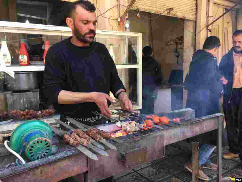 A man makes kabobs at the market in Mosul, Iraq, in February 2017. (K. Omar/VOA)