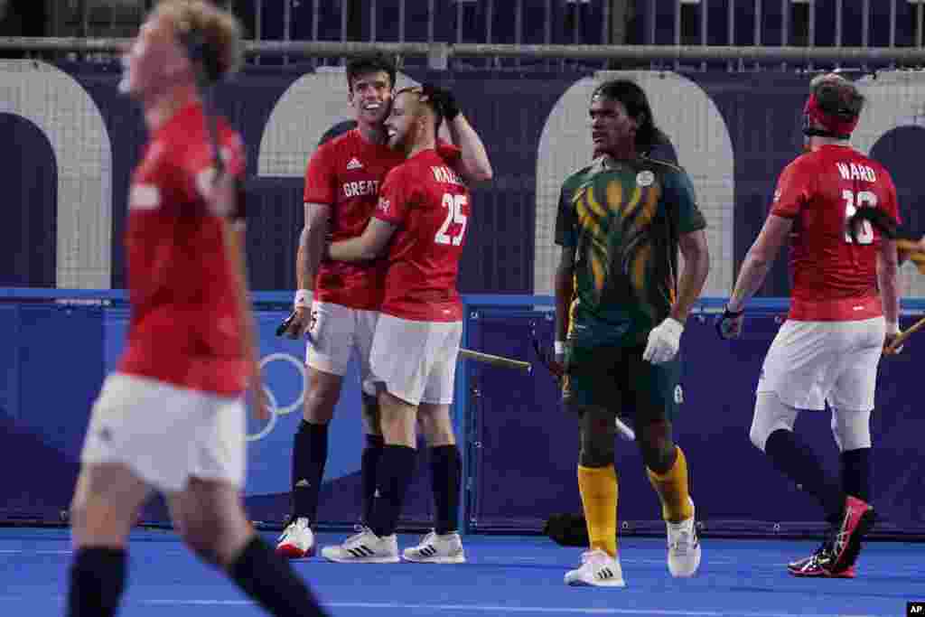 Great Britain's Phillip Roper, left, embraces Jack Waller (25) after Waller scored against South Africa during a men's field hockey match at the 2020 Summer Olympics, Saturday, July 24, 2021, in Tokyo, Japan. (AP Photo/John Locher)