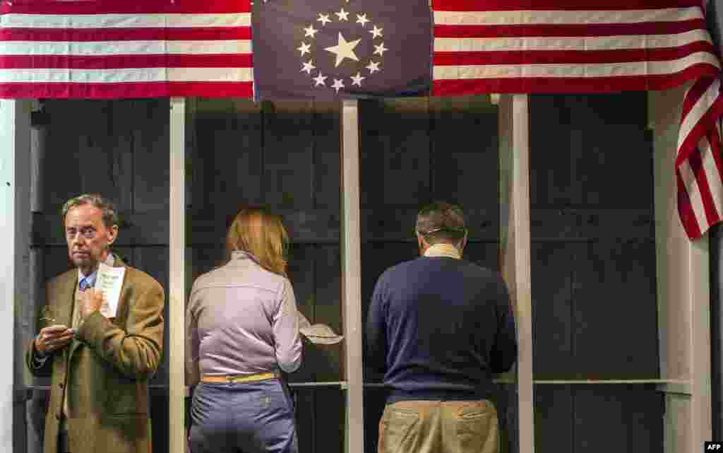 People prepare to cast their ballots inside a polling station just after midnight on November 6, 2012 in Dixville Notch, New Hampshire, the very first voting to take place in the 2012 U.S. presidential election. 