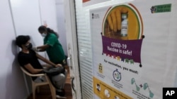 A health worker administers the COVISHIELD vaccine for COVID-19 at a vaccination center in Mumbai, India, Monday, May 3, 2021. (AP Photo/Rafiq Maqbool)