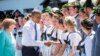 German Chancellor Angela Merkel, left, and U.S. President Barack Obama are welcomed by local residents in their traditional costumes during their visit in the village of Kruen, southern Germany, June 7, 2015.