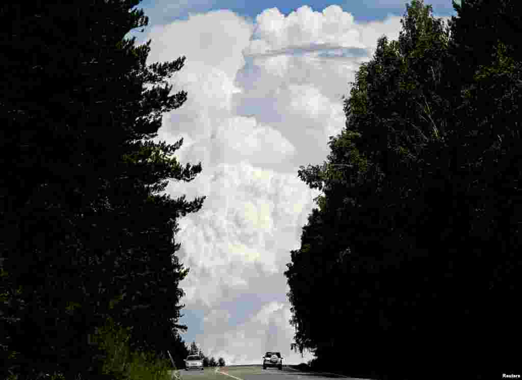Cars drive along the "Yenisei" M54 federal highway, with heavy clouds seen in the sky, through the Siberian Taiga area outside Krasnoyarsk, Russia.