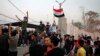 Protesters raise the Iraqi flag at the gate of the Iranian consulate building before storming and burning it in Basra, 340 miles (550 km) southeast of Baghdad, Iraq, Sept. 7, 2018. 
