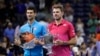 Novak Đoković i Sten Vavrinka sa trofejima namenjenim pobedniku i poraženom u finalu