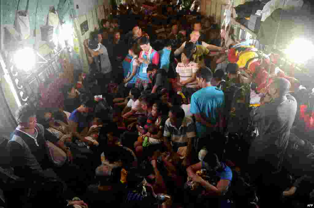 Para korban topan di Filipina yang selamat berada di dalam pesawat militer C-130 dari Tacloban, provinsi Leyte, menuju Manila.