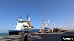 FILE - A coastguard walks past a ship docked at the Red Sea port of Hodeida, Yemen, Jan. 5, 2019. 