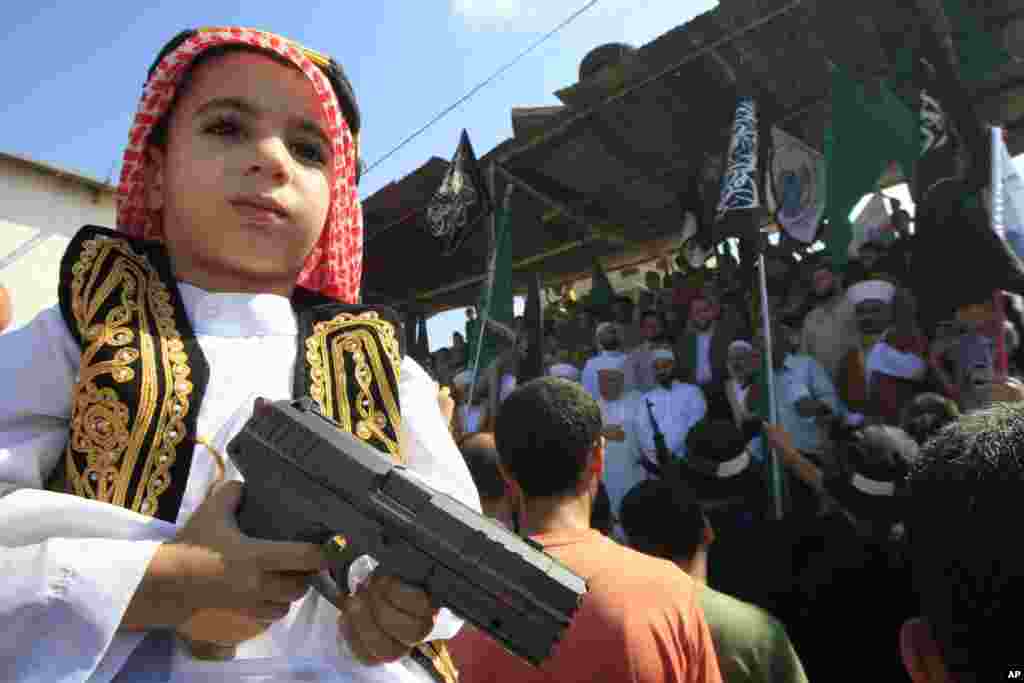 Seorang anak lelaki memegang mainan senjata dalam demonstrasi di kamp pengungsi Palestina, Ain el-Hilweh, dekat Sidon, Libanon (14/9).