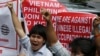 Vietnamese expatriates shout slogans in front of the Chinese Consulate at the financial district of Makati city to protest the recent moves by China to construct an oil rig near the Vietnamese-claimed Paracels, May 16, 2014. 
