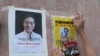 An activist pastes images of Thai dissident Wanchalearm Satsaksit on a wall near the Cambodian Embassy in Bangkok, Thailand, Monday, June 8, 2020. (AP Photo/Sakchai Lalit)