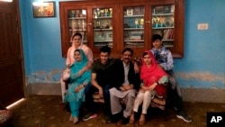 Pemenang Hadiah Nobel Perdamaian Pakistan Malala Yousafzai (dua dari kanan), foto bersama anggota keluarganya dan Menteri Informasi Pakistan Marriyum Aurangzeb (kanan), di rumah asalnya selama kunjungan ke Mingora, kota utama Pakistan Swat Valley, Sabtu, 31 Maret 2018.
