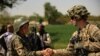 FILE - A U.S. soldier, right, shakes hands with an Afghan National Army soldier before the opening ceremony for a newly completed mosque in southern Kandahar province, April 1, 2011, where the U.S. is funding its rebuilding.