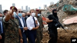 French President Emmanuel Macron, center, visits the devastated site of the explosion at the port of Beirut, Lebanon, Aug.6, 2020.
