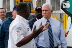 Vice President Mike Pence, right, talks with Walmart truck driver Earnest Allen at a Walmart Distribution Center, April 1, 2020, in Gordonsville, Va.