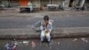 A child sits along a road median as he eats his breakfast of a single piece of "roti" (South Asian bread) while waiting for work in Karachi early morning May 6, 2012.