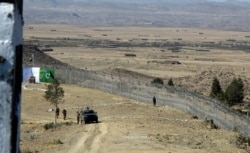 FILE - Pakistani soldiers stand guard at a newly erected fence between Pakistan and Afghanistan at Angore Adda, Pakistan, Oct. 18, 2017.
