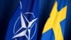 Bendera Swedia (kanan) dan NATO saat konferensi pers Perdana Menteri Swedia dengan Sekretaris Jenderal NATO pada 24 Oktober 2023 di Stockholm, Swedia. (Foto: AFP)