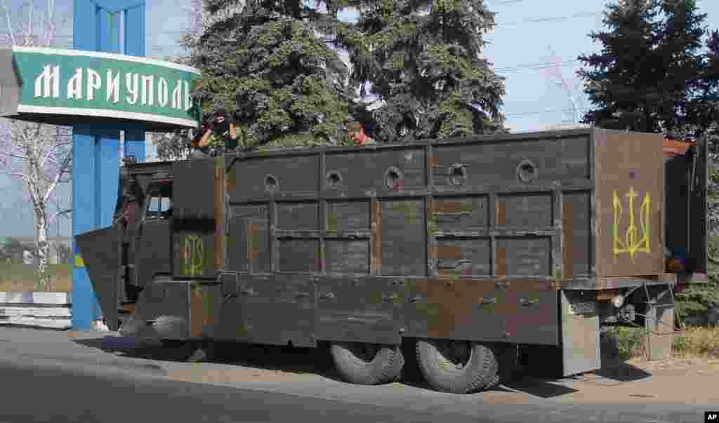 An armored truck with Ukrainian forces guards a checkpoint in the town of Mariupol, eastern Ukraine, Aug. 28, 2014. 