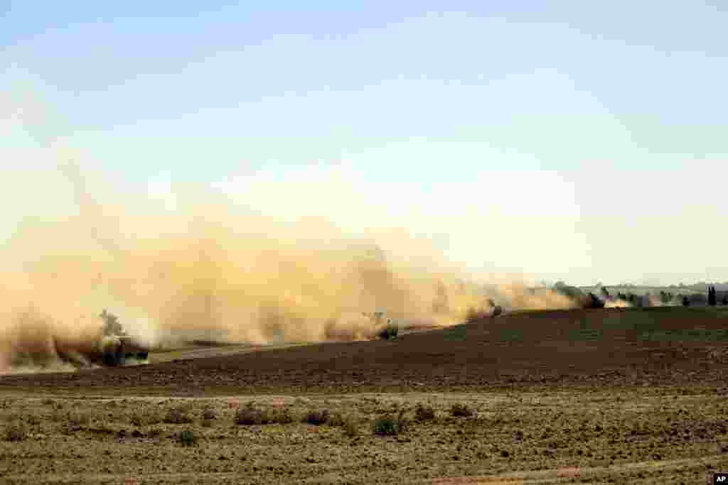 Israeli Merkava tanks and armored personnel carriers drive in southern Israel as they advance towards the Israel-Gaza border, Aug. 1, 2014.