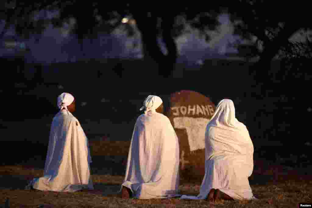 Women pray before casting their ballots in the country's general elections in Harare, July 30, 2018.
