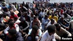Illegal African migrants sit during a visit by U.N. officials at a detention camp in Tripoli, Libya, March 22, 2017.