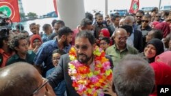 FILE - Maldives opposition leader Qasim Ibrahim, center, is welcomed at the airport as he returned home from exile in Male, Maldives, Thursday, Oct. 4, 2018.
