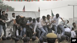 Communist Party of India (Marxist) activists raise slogans at a protest against inapt handling by the central government of alleged corruption charges pertaining to the Commonwealth Games, the Adarsh Society land scam and the 2-G telecom scam, in New Delh