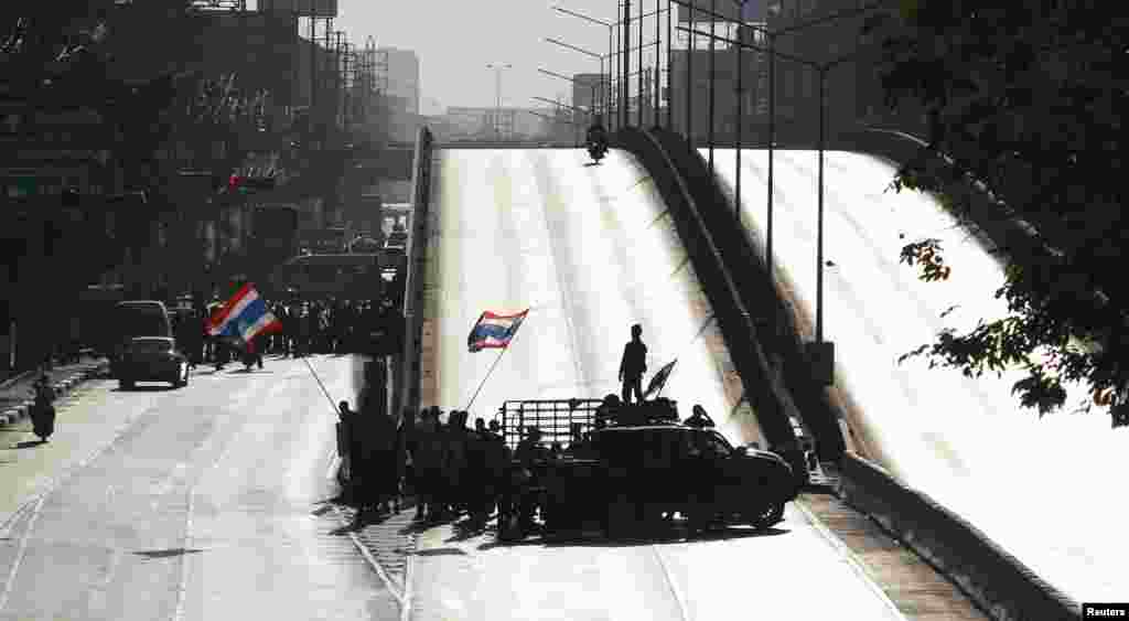 Anti-government protesters block a road in central Bangkok. Thousands of protesters began a blockade at major intersections in Bangkok as they sought to paralyze Thailand's capital, stepping up pressure on Prime Minister Yingluck Shinawatra to resign.