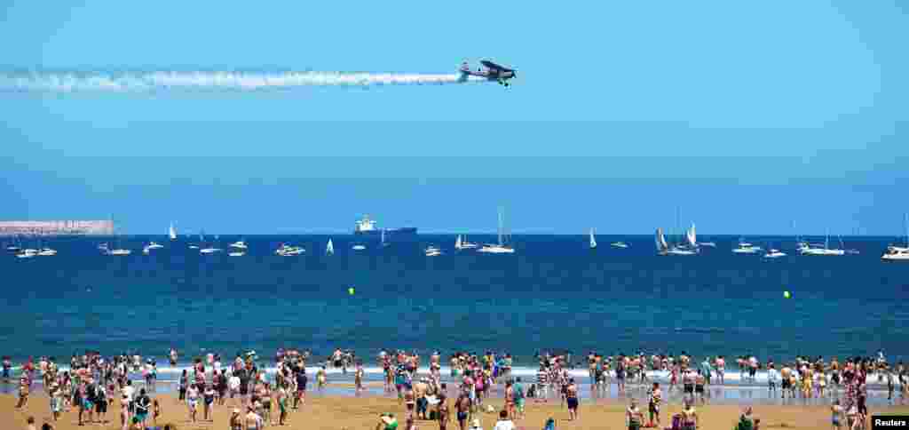 A Cessna L19 Bird Dog flies over San Lorenzo beach during an aerial exhibition in Gijon, northern Spain.