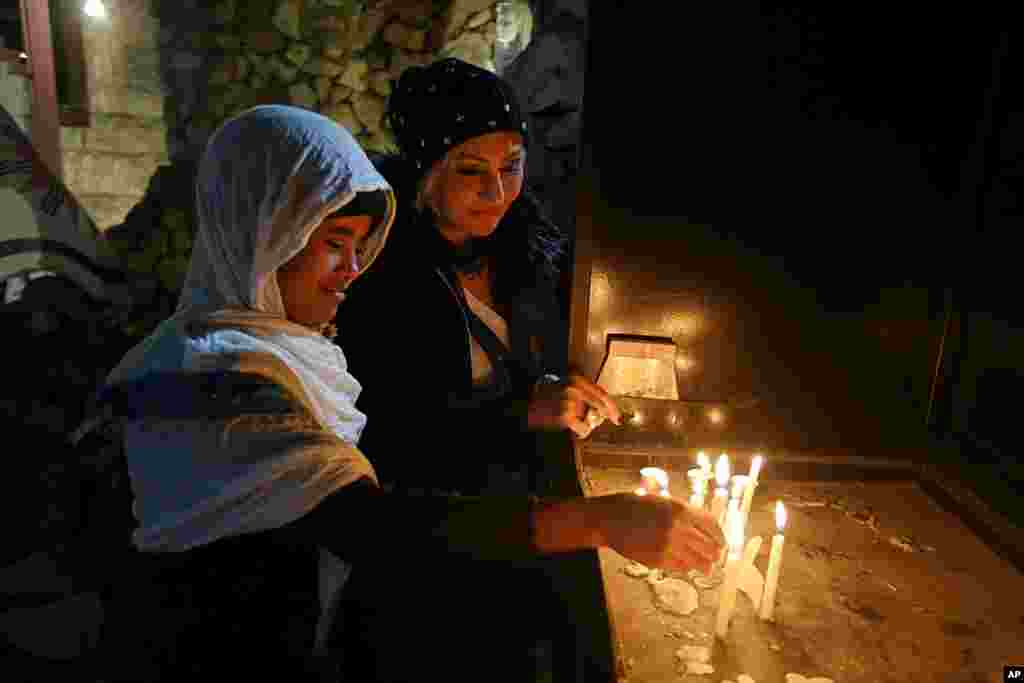 Iraqi Christians light candles after a Christmas Eve Mass in St. Joseph&#39;s Church in Baghdad, Dec. 24, 2017.