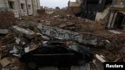 Sebuah mobil terlihat di bawah puing-puing masjid yang diserang oleh seorang pelaku bom bunuh diri pada Januari lalu, di kawasan Garis Polisi di Peshawar, Pakistan, 9 Februari 2023. (Foto: Reuters)