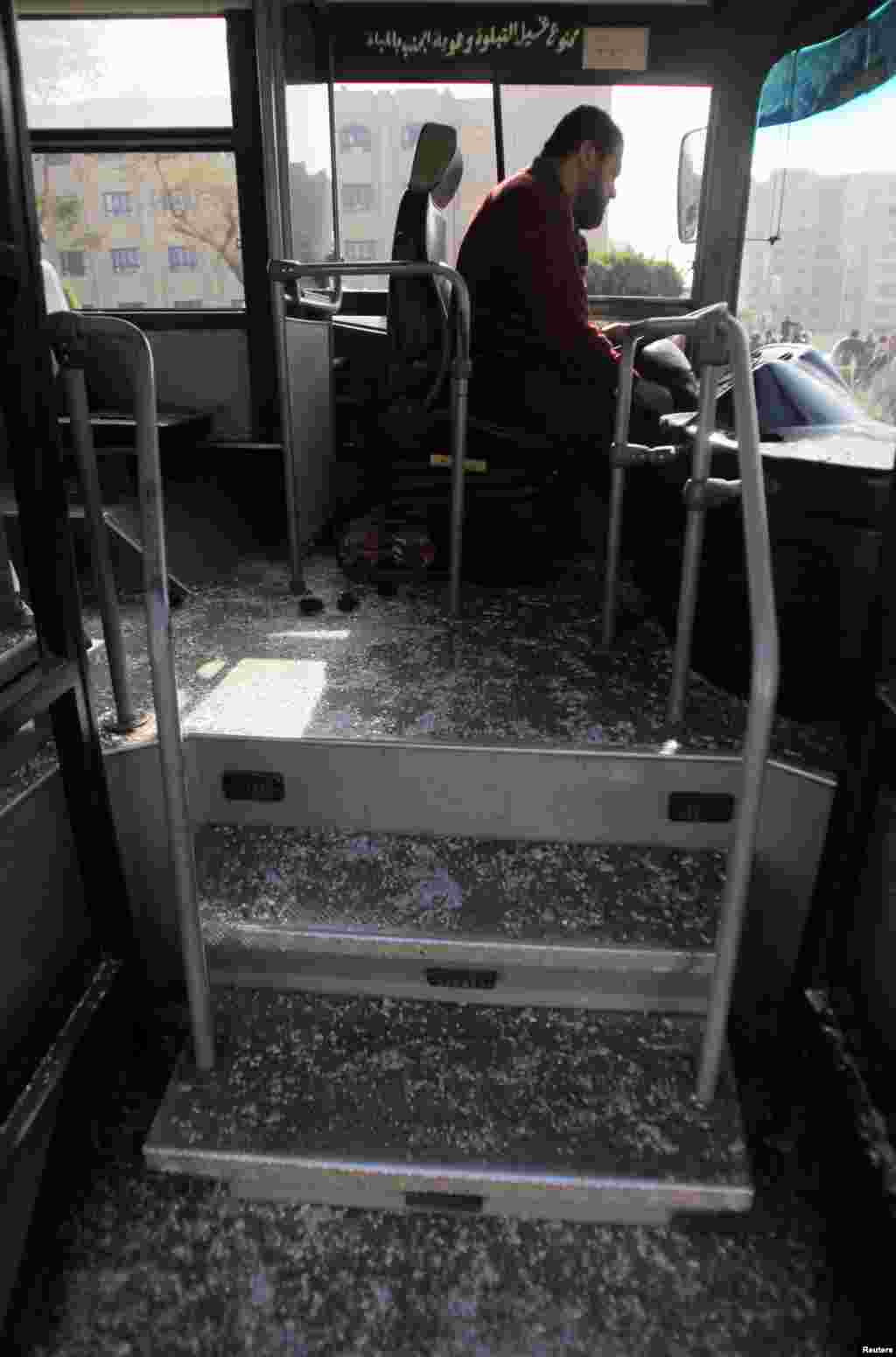 Bus driver Adel Abd El Fatah sits inside a damaged bus after a bomb blast near the Al-Azhar University campus in Cairo's Nasr City district, Dec. 26, 2013.