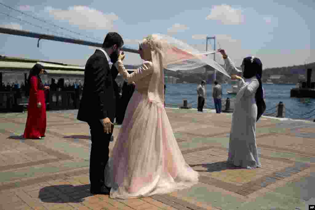 A new married couple poses for photos in front of the Bosporous bridge in central Istanbul, Turkey. Rather than toppling the country's strongman president, a failed military coup appears to have bolstered Recep Tayyip Erdogan's immediate grip on power and boosted his popularity.