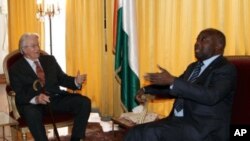 Former French foreign minister Roland Dumas (L) talks with Ivory Coast leader Laurent Gbagbo at the presidential palace in Abidjan, Dec 30 2010.